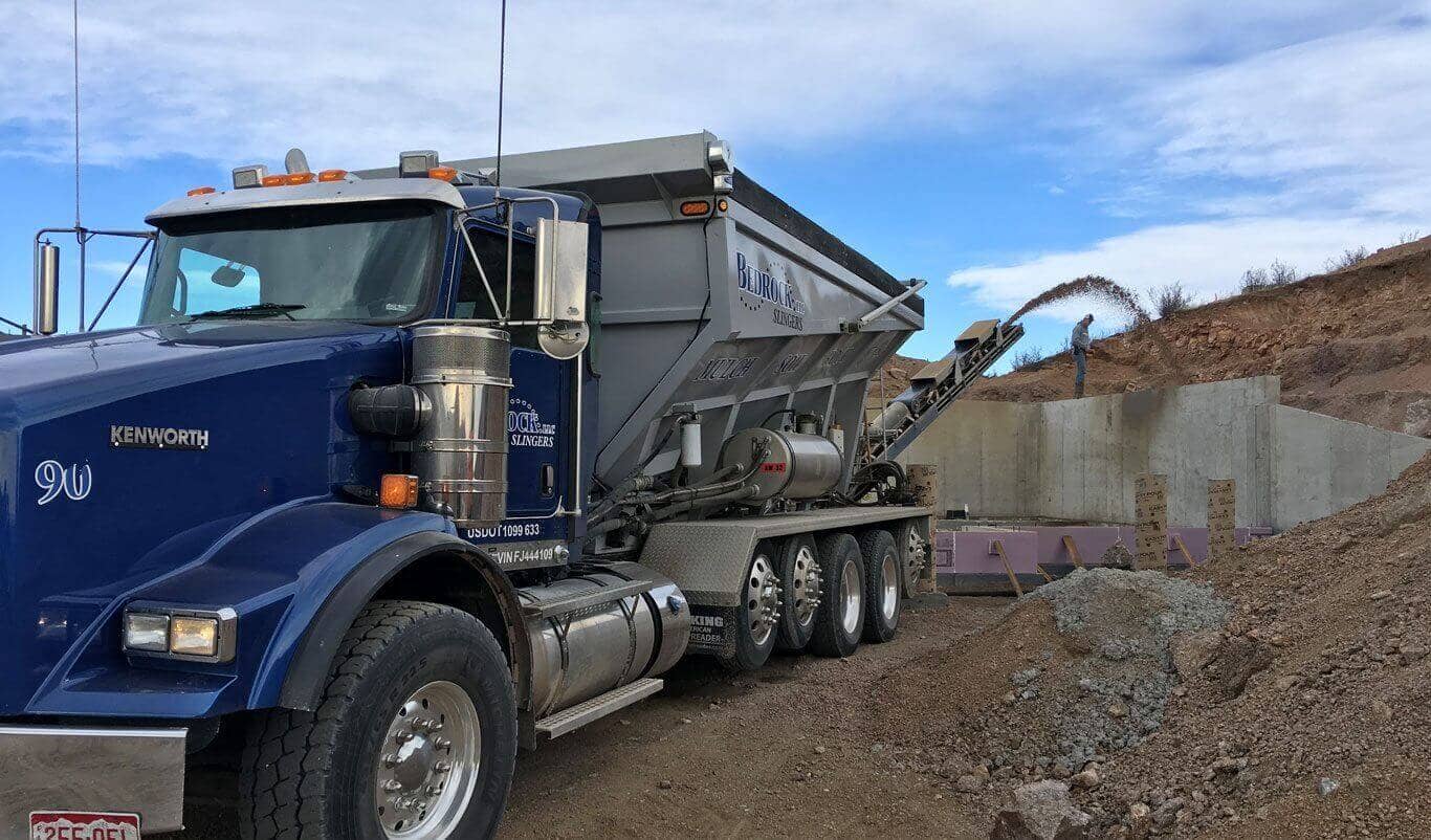 Bedrock Slinger's crew installed perimeter drain and backfilled with rock using slinger trucks