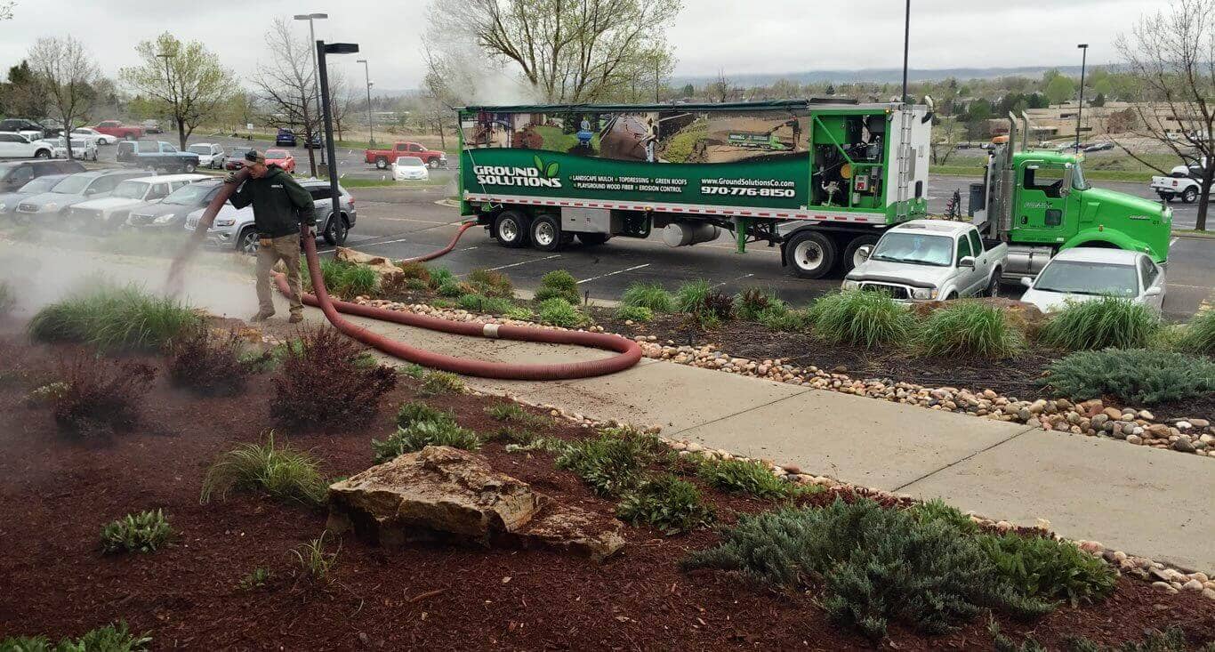 recycled, dyed mulch around a commercial property using blower trucks