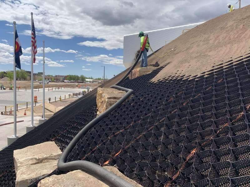Ground Solutions placing planters mix onto sloped surface with GEOWEB at the US Olympic Museum in Colorado